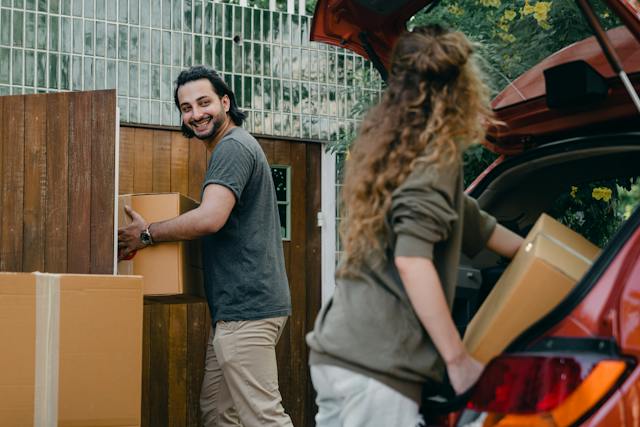 couple unloading automobile while moving apartment