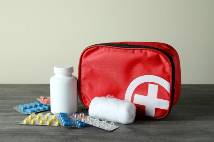 First aid medical kit on gray textured table