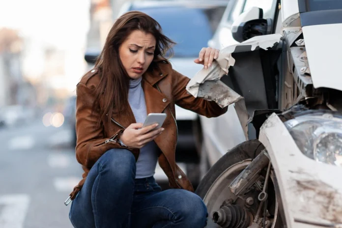 woman text messaging on smart for after a car crash on the road