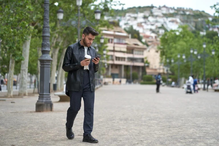 Young man using mobile phone in city