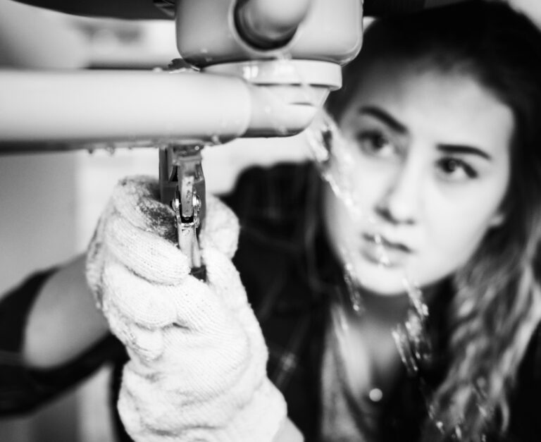 Woman fixing the kitchen sink