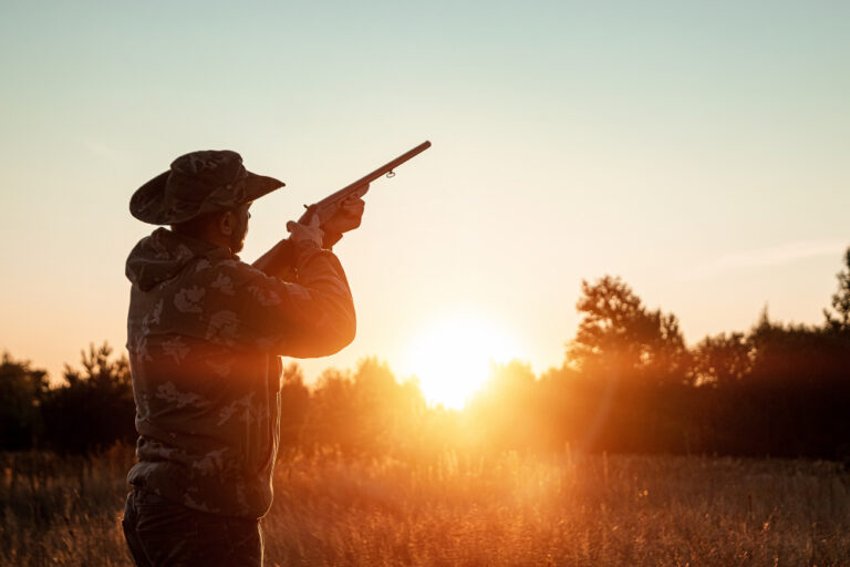 Hunter in a cowboy hat with a gun in his hands